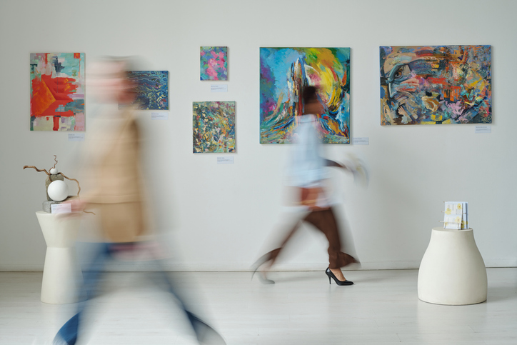 Personen laufen durch das Kunstmuseum vorbei an bunten Bildern